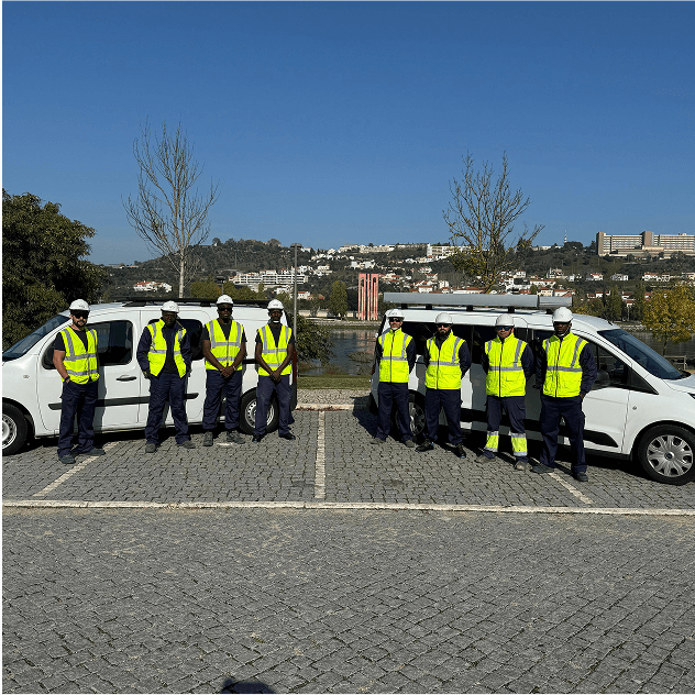 Team of solar panel installers in safety equipment standing next to company vans